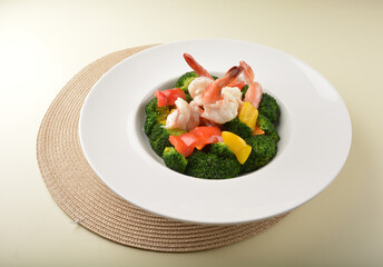 stir fried green broccoli with fresh big tiger prawn and bell pepper in oyster sauce in white plate asian halal menu