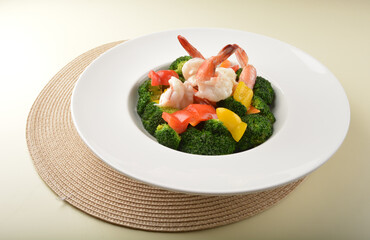 stir fried green broccoli with fresh big tiger prawn and bell pepper in oyster sauce in white plate...