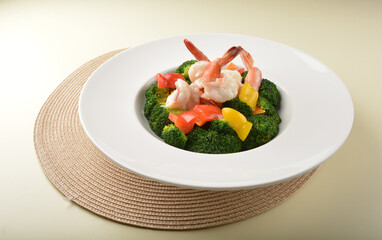 stir fried green broccoli with fresh big tiger prawn and bell pepper in oyster sauce in white plate asian halal menu