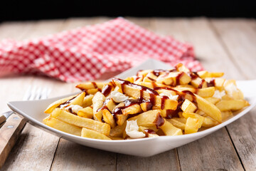 Traditional Canadian Poutine on wooden table	