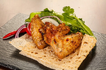 Grilled chicken wings served onion