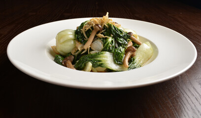 stir fried vegetable nai bai with garlic and mushroom in oyster sauce in white plate asian halal menu