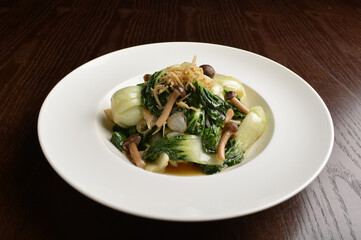 stir fried vegetable nai bai with garlic and mushroom in oyster sauce in white plate asian halal menu