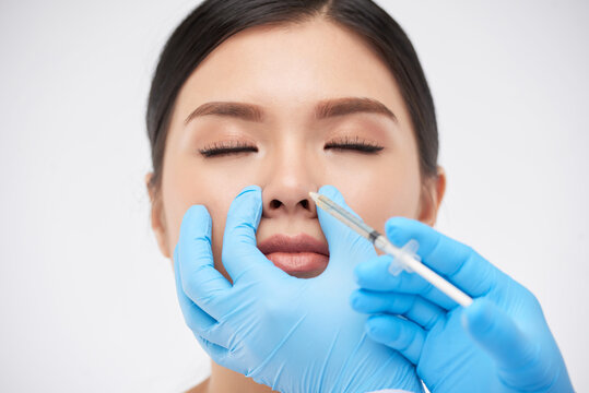 Young woman getting nonsurgical rhinoplasty at plastic surgery clinic