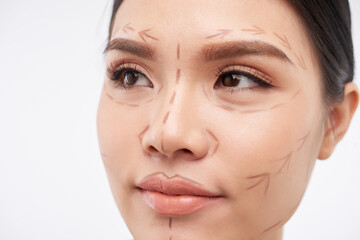 Obraz premium Face of attractive young woman with marks for facial plastic surgery, beauty and cosmetology concept