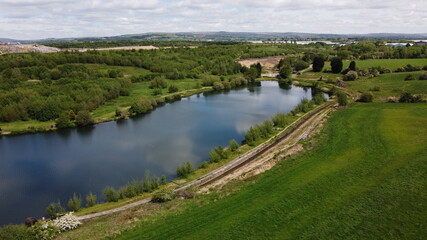 Fototapeta premium Drone image looking down onto a lake with green farmland surrounding. Taken in Lancashire England. 