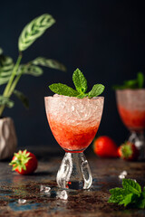 Beautiful composition with fresh cocktail with crushed ice, strawberry and mint on old rusty blue metal table. Summer cold drink concept