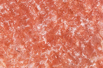 Texture of rough porous relatively flat edge of red stone