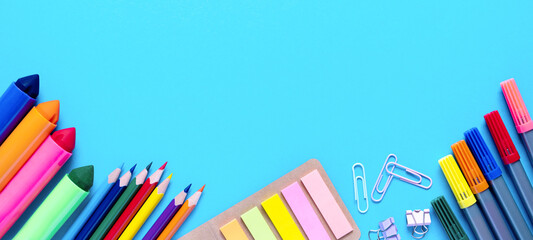 Wide banner. Colorful pencils, felt-tip pens, brushes, stickers and stationery flat lay. School...