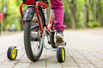 The child is riding a tricycle in the park.