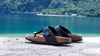 Close-up of beach sandals with the lake in the background