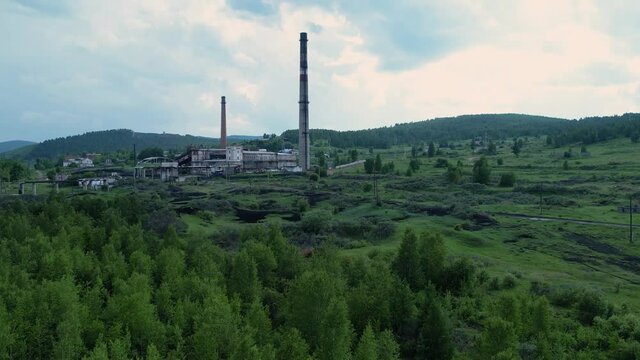 an old thermal power plant outside the city against the background of nature and a green forest