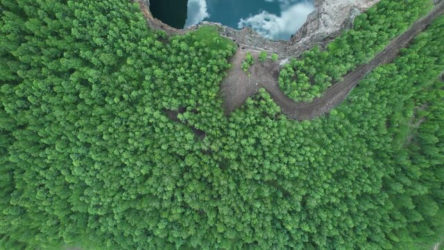 mountain lake reflection and clouds in turquoise water and coniferous green forest. Tuimsky sinkhole-man-made disaster or tectonic fault collapse of a mine in Khakassia, Russia. like a gateway to hell