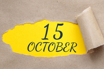 october 15. 15th day of the month, calendar date.Hole in paper with edges torn off. Yellow background is visible through ragged hole.Autumn month, day of the year concept