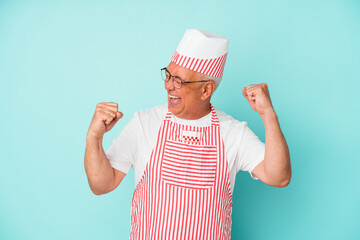 Senior american ice cream man woman holding isolated on blue background raising fist after a victory, winner concept.