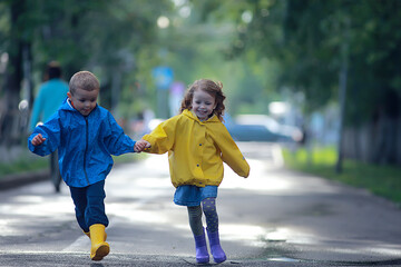 boy and girl children on an autumn walk in the park / autumn park, raincoats for children, family