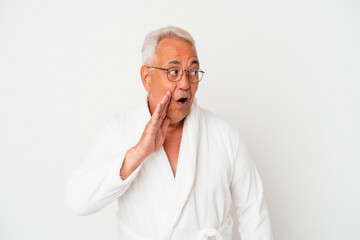 Senior american man wearing bathrobe isolated on white background is saying a secret hot braking news and looking aside