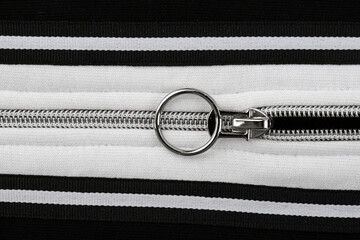 a fragment of a sewing product, polyester clothing, double seam, zipper made of white metal