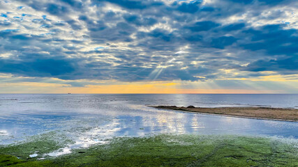 Panorama of the warm Gulf of Riga of the Baltic Sea against the background of cumulus clouds at sunset. The coast of the Gulf of Riga in Latvia is popular with tourists.