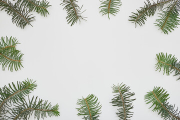 Christmas frame made of green fir tree branches on white background