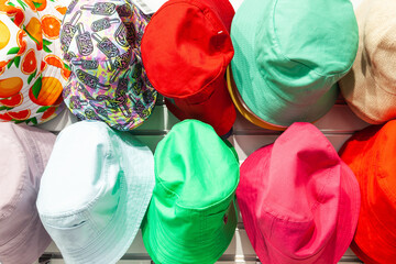 Summer hats in different colors in the store, close-up. Multi-colored summer panamas hang in the store.