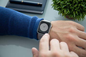male hands with wristwatch on table in office