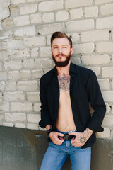 A handsome young man with a beard in a grunge-style interior