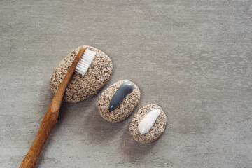 Eco friendly bamboo toothbrush and toothpaste on a grey stone background. Healthcare, dental care concept.