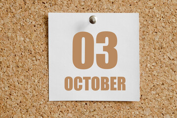 october 03. 03th day of the month, calendar date.White calendar sheet attached to brown cork board.Autumn month, day of the year concept