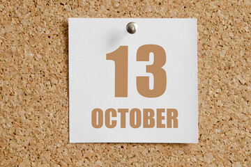 october 13. 13th day of the month, calendar date.White calendar sheet attached to brown cork board.Autumn month, day of the year concept