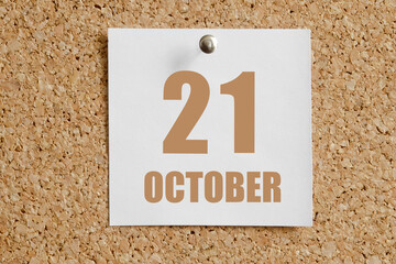 october 21. 21th day of the month, calendar date.White calendar sheet attached to brown cork board.Autumn month, day of the year concept