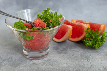 Summer salad with grapefruit on a light background with herbs.