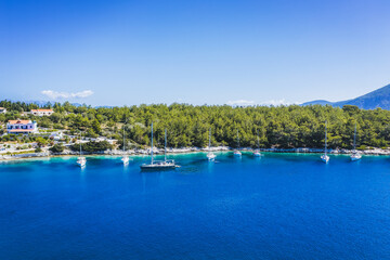 Fototapeta na wymiar Aerial photo of sailing boats docked in blue bay of Fiskardo, Kefalonia island, Ionian, Greece