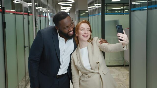 Multiracial office workers laugh and take selfies during a break at work in the office