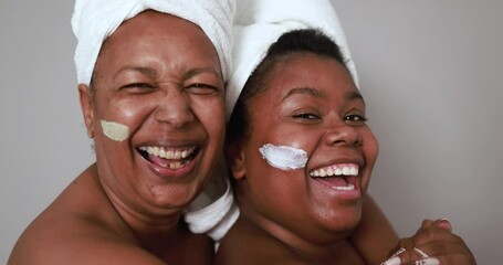 African mother and daughter doing beauty treatment at home using skin mask - Body care and family concept - Powered by Adobe