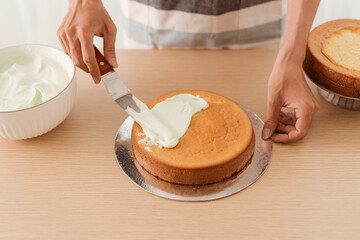 Pastry chef puts the cream on the Cakes. Process cooking sponge cake.