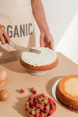 Man pastry chef put icing cream on sponge cake. Making sponge cake series