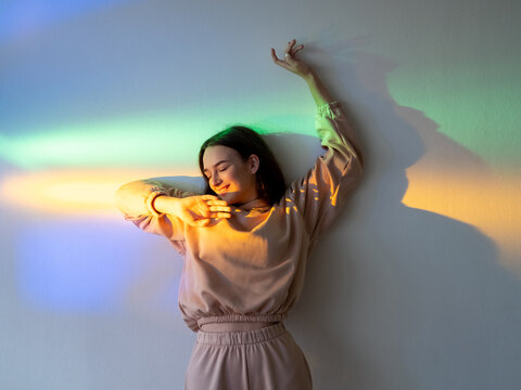 Neon light woman. Positive lifestyle. Carefree joy. Happy youth. Cheerful smiling girl relaxing enjoying sunshine on smooth rainbow color gleam gradient.