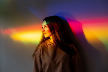 Neon light girl. Fashion model. Rainbow portrait. Peace harmony. Attractive young woman side looking on glowing bright spectrum gradient.