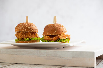 mini Chicken burgers with lettuce and sticks on a wooden background - obrazy, fototapety, plakaty