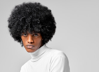 Portrait of african american man with natural black afro hair isolated on gray background