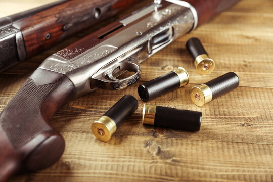 hunting rifles and cartridges are on wooden background, studio photo shot. hunter guns and bullets close up