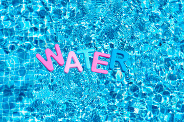 Word water in colors floating over a pool. copy space
