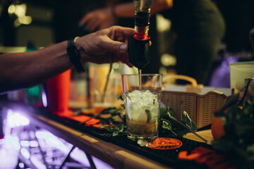 Fototapeta na wymiar Preparing Mojito in a bar, a glass of crushed ice and lime, fresh mint nearby.
