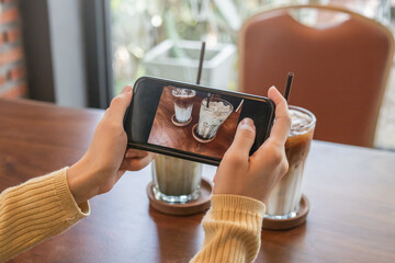 Food, foodie photography hand of woman using smart, mobile phone or cellphone, taking picture, photo of latte coffee in cafe, shop or restaurant while travel, weekend. Technology of social media.