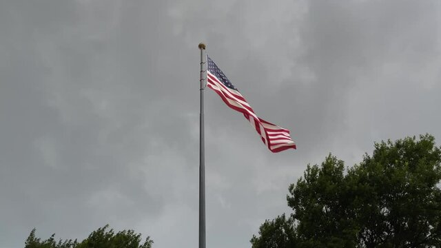 USA flag moving on the wind against grey sky