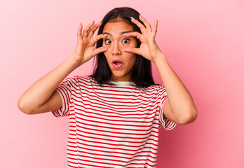 Young Venezuelan woman isolated on pink background keeping eyes opened to find a success opportunity.