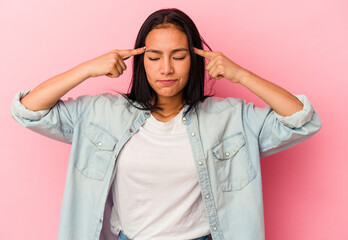 Young Venezuelan woman isolated on pink background focused on a task, keeping forefingers pointing head.