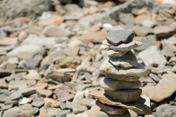 Tower of flat stones, sea, mountain, river, tourist recreation, free space for insertion, selective focus.