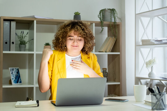 Achieve result. Online success. Job promotion. Dream goal. Happy satisfied curly hair overweight business woman at laptop reading email in light home office.
